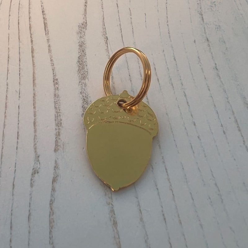 Brass Acorn Shape on Wood Background