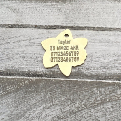 Brass Flower Shaoe with Engraved Text on Wood Background